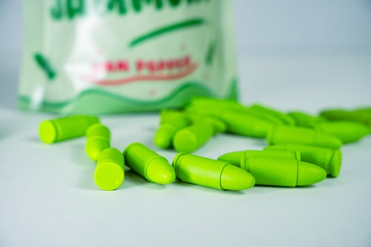 A pack of Jolly Jammers, green 9MM malfunction rounds, displayed with several rounds scattered in front.