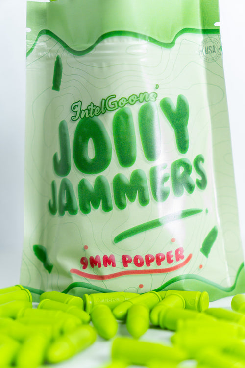 A pack of Jolly Jammers, green 9MM malfunction rounds, displayed with several rounds scattered in front.