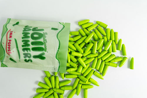A pack of Jolly Jammers, green 9MM malfunction rounds, displayed with several rounds scattered in front.