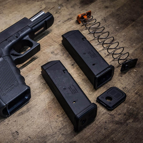 Disassembled PMAG GL9 next to Glock handgun